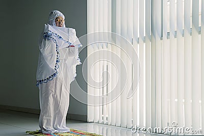 Senior muslim woman doing salat at home Stock Photo