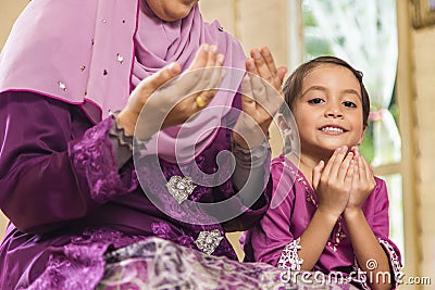 Senior Muslim woman and her granddaughter saying prayers Stock Photo