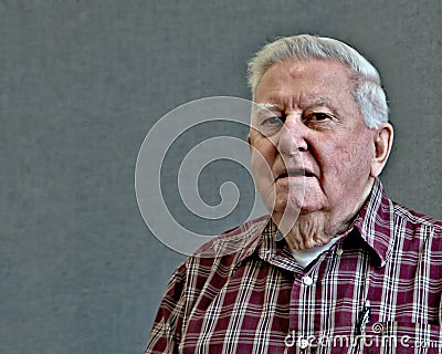 Senior octogenarian old man in plaid with gray background. Stock Photo