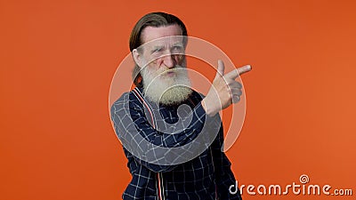 Senior old bearded man pointing around with finger gun gesture, shooting killing with hand pistol Stock Photo
