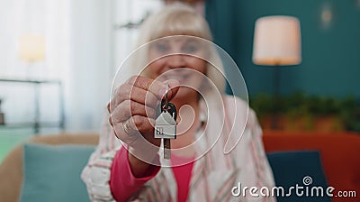 Senior old woman customer landlord hold key to new house real estate owner make sale rental purchase Stock Photo