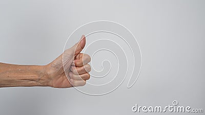 Senior or older woman`s hand doing thumbs up sign on white background Stock Photo