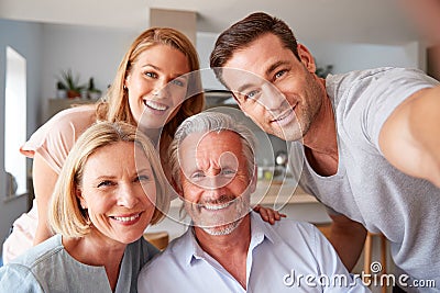 Senior Parents With Adult Offspring Posing For Selfie At Home Stock Photo