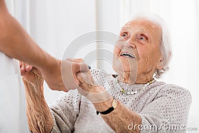 Senior Patient Holding Hands Of Female Doctor Stock Photo