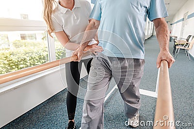 Senior Patient and physical therapist in rehabilitation walking exercises Stock Photo