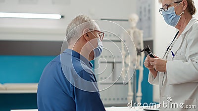 Senior physician doing ear examination with otoscope Stock Photo