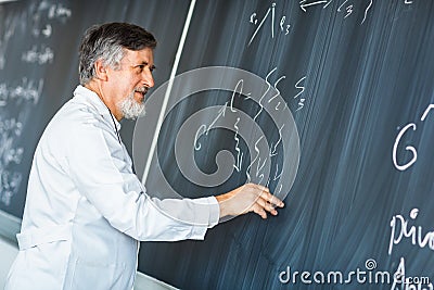 Senior professor writing on the board Stock Photo