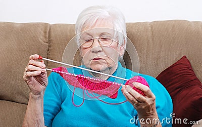 Senior putting away her knitting Stock Photo