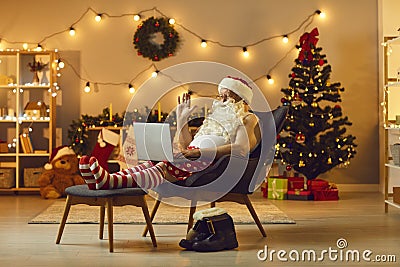 Senior Santa in funny home festive costume chatting online with family Stock Photo