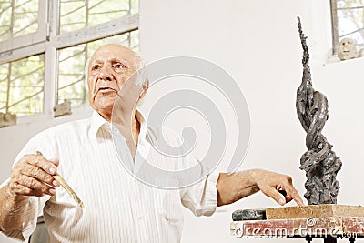 Senior sculptor describing his sculpture Stock Photo