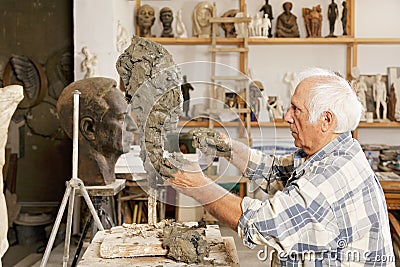 Senior sculptor making sculpture sideview Stock Photo