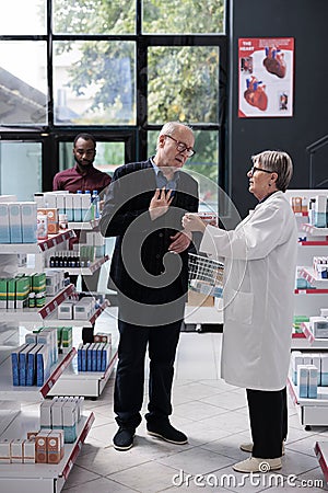 Senior specialist explaining cardiology pills treatment to old man customer Stock Photo