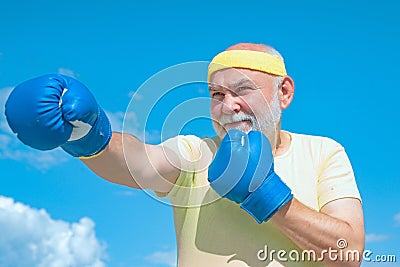Senior sportive man in boxing stance doing exercises with boxing gloves. Active leisure. Best cardio workout. Stock Photo