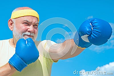 Senior sportive man in boxing stance doing exercises with boxing gloves. Active leisure. Best cardio workout. Stock Photo