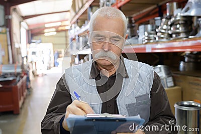 Senior stock keeper working in warehouse Stock Photo