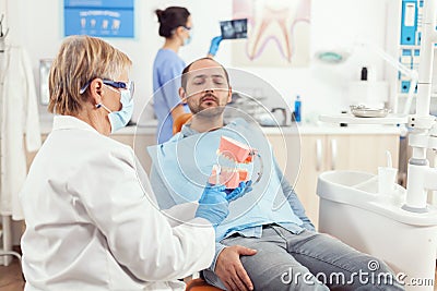 Senior stomatologist explaining to sick patient dental procedure Stock Photo