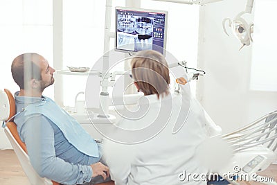 Senior stomatologist woman discussing with sick man about healdcare treatment Stock Photo