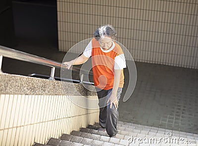 senior Suffering from knee Pain on stair Stock Photo