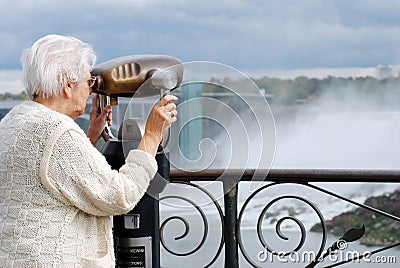 Senior tourist using binoculars at niagara falls Stock Photo