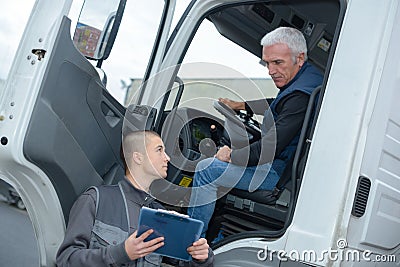 Senior truck driver taking to manager Stock Photo