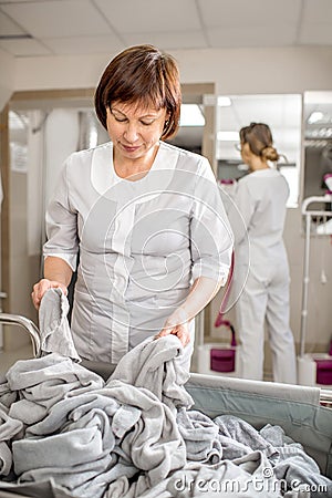 Senior washwoman working in the laundry Stock Photo