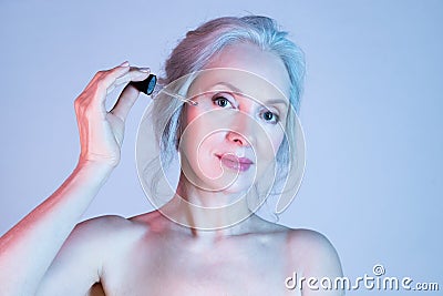 Senior woman apply moisturizing skin serum Stock Photo