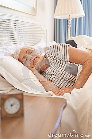Senior woman asleep in her bed in the morning Stock Photo