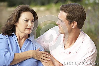 Senior Woman Being Comforted By Adult Son Stock Photo