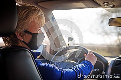 Senior woman in black protective mask and inside a car Stock Photo