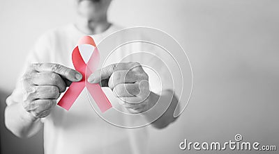 Senior woman in black and white support Breast Cancer Day by holding Pink Ribbon Breast Cancer Awareness with copy space. Stock Photo