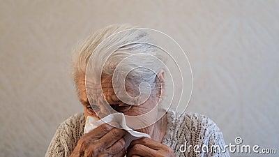 Senior woman blows her nose in a handkerchief. Stock Photo