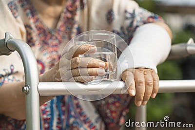 Senior woman broken wrist using walker Stock Photo