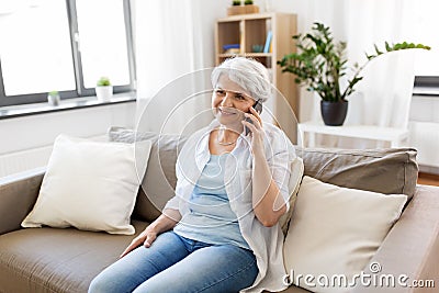 Senior woman calling on smartphone at home Stock Photo