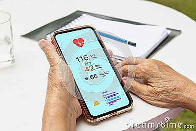 Senior woman checking blood pressure hypertension vai mobile phone Stock Photo