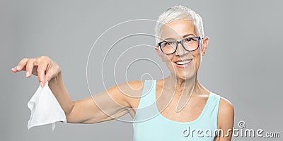 Senior woman cleaning hands and dropping wet wipes - care for health and prevention of infectious diseases Stock Photo