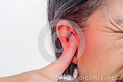 Senior woman closes ears with fingers to protect from loud noise Stock Photo