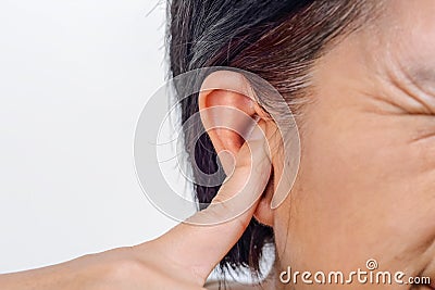 Senior woman closes ears with fingers to protect from loud noise Stock Photo