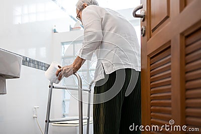 Senior woman with diarrhea holding tissue roll near a toilet bowl,elderly have abdominal pain,stomach ache,constipation,sick Stock Photo