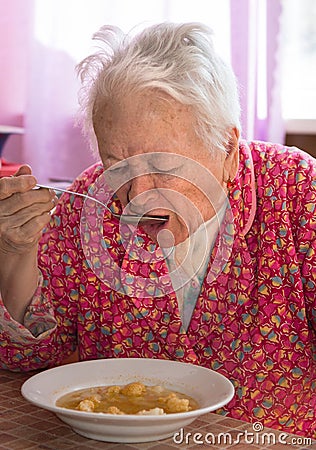 Senior woman eating soup Stock Photo