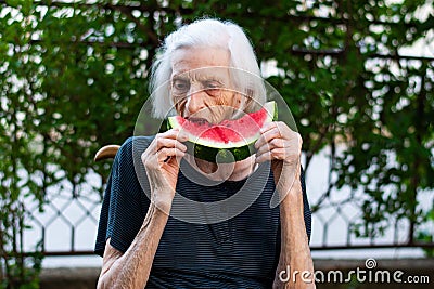 Senior woman eating watermelon outdoors Stock Photo