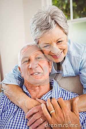 Senior woman embracing man at home Stock Photo