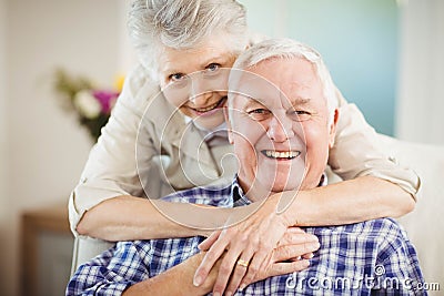 Senior woman embracing man at home Stock Photo
