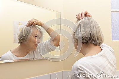 Senior woman examining hair loss Stock Photo