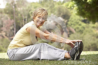 Senior Woman Exercising In Park Stock Photo