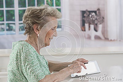 Senior woman with eyeglasses browsing on digital tablet Stock Photo