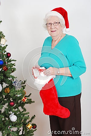 Senior woman filling christmas stocking Stock Photo