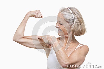 Senior woman flexing muscles against white background Stock Photo
