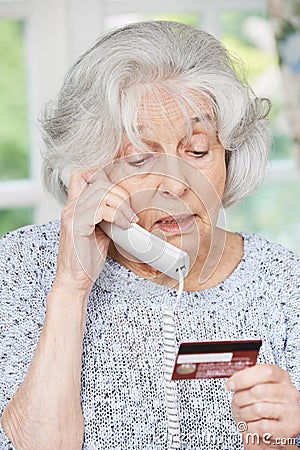 Senior Woman Giving Credit Card Details On The Phone Stock Photo
