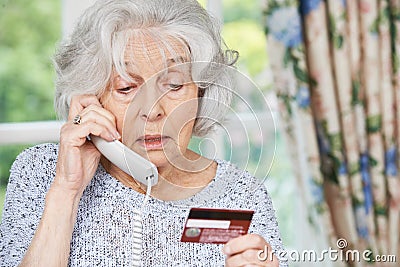 Senior Woman Giving Credit Card Details On The Phone Stock Photo