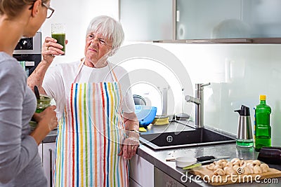 Senior woman/grandmother cooking in a modern kitchen with her grand-daughter Stock Photo